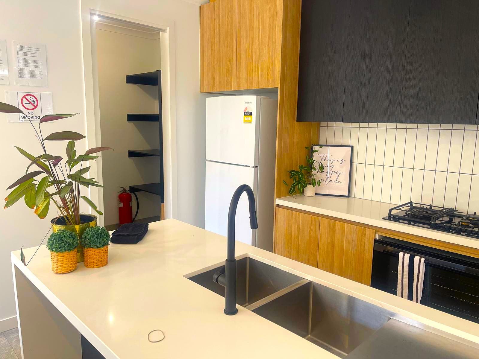 Kitchen at the Deanside home with an island bench, double sink and gas cooktop.