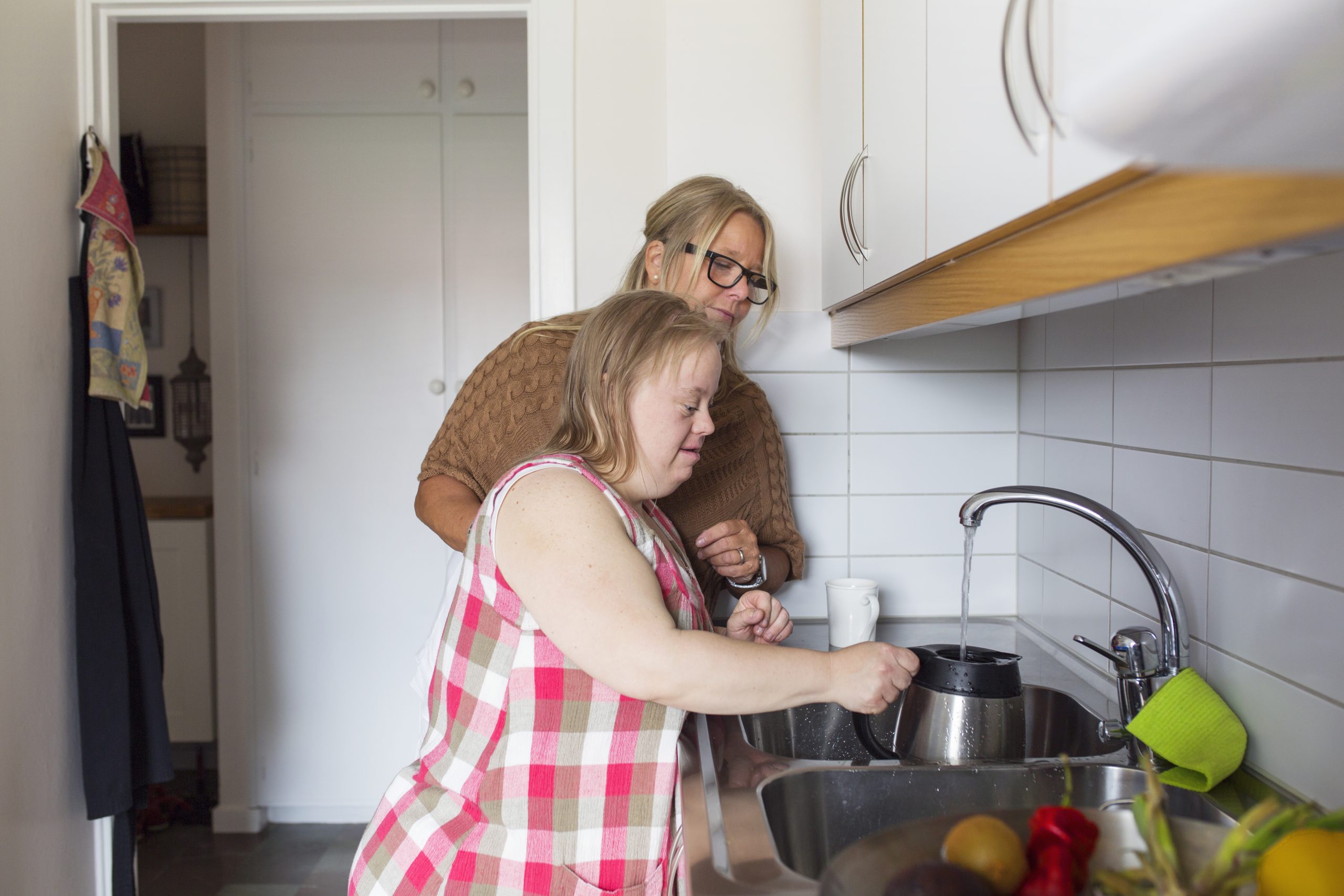 Mother and daughter with down syndrome in kitchen