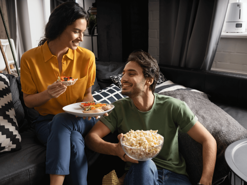 couple-eating-together-home-sofa-1 couple-eating-together-home-sofa-1